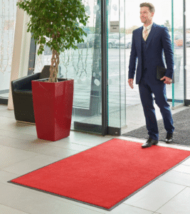 Punane ühevärviline porivaip kontori sissepääsu ees