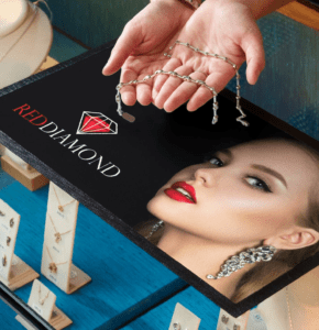 Leti reklammatt, millel on brändi logo ja kus esitletakse ehteid