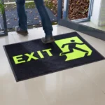 Neoonkollase kirjaga ohutusmatt Exit väljapääsu ees