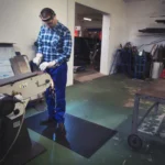 Tööline seismas Floorstudio mustal kummimatil töökojas