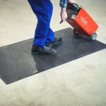 Floorstudio musta kummimati puhastamine survepesuriga välitingimustes