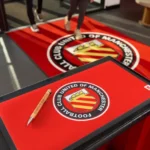 Punane jalgpalliklubi logoga reklaammatt letil ja põrandal