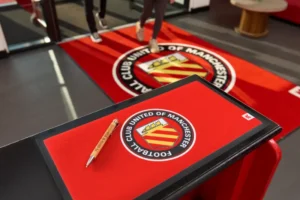 Punane jalgpalliklubi logoga reklaammatt letil ja põrandal
