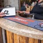 Must logomatt kohvikuletil koos latte art kohvitassidega