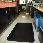 Ergonoomilised matid 40 Must ergonoomiline matt paigaldatuna puidust baarileti taha põrandale