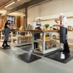 Ergonoomilised matid 45 Kokad ja teenindajad seismas FloorStudio mustadel ergonoomilistel mattidel modernses suurköögis