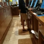 Pruunid ergonoomilised matid hotelli vastuvõtulaua taga teenindajate jalgade all