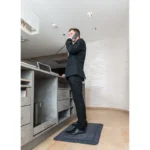 Mees seismas helehallil ergonoomilisel matil kaasaegses valges kontoris