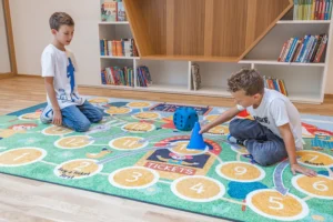 Mängumatt haridusasutustele, lapsed mönguvad vörvilisel trükitud FloorStudio logomatil